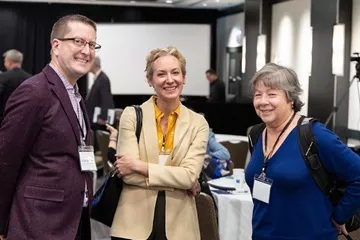Photo of three people smiling at a CRL event.