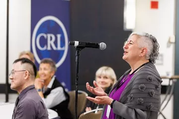 Photo of a person participating in a CRL event using a microphone.