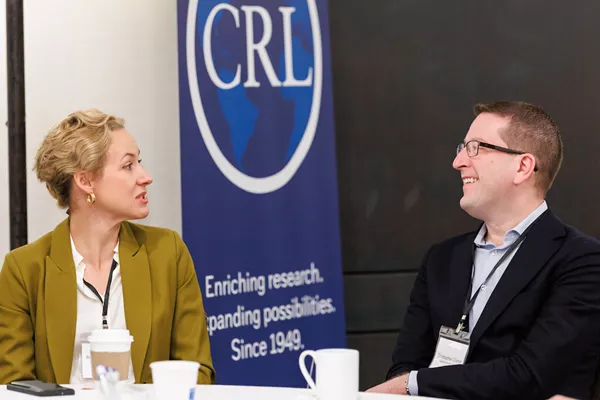 Photo of two CRL members talking at an event.